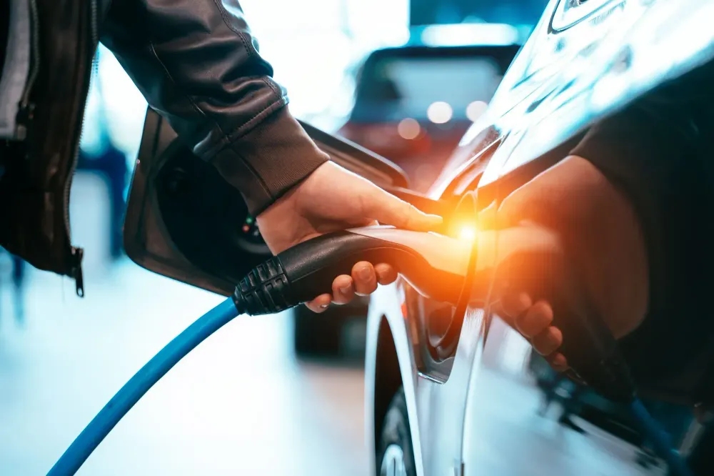 Close up of hand plugging in an electric car